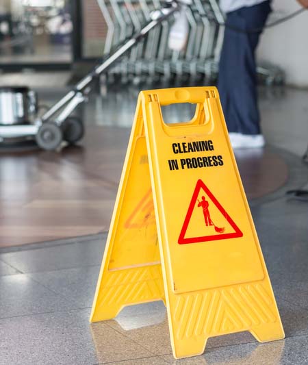 Woman worker cleaning the floor with polishing machine