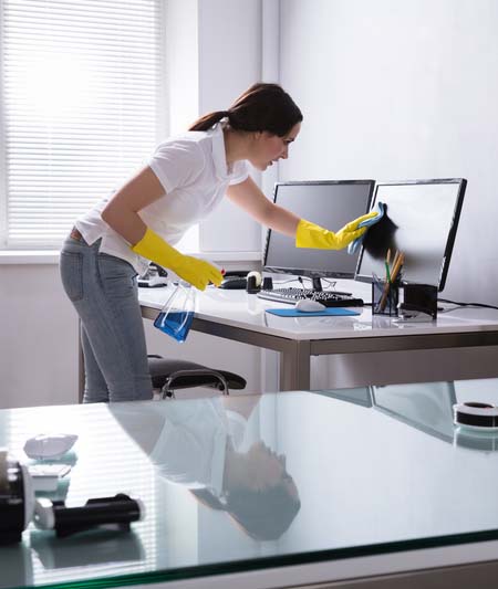 Woman Cleaning Computer In Office. Young Woman Cleaning Computer With Rag In Office
