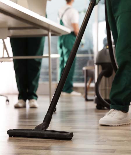 Professional janitor cleaning floor in modern office